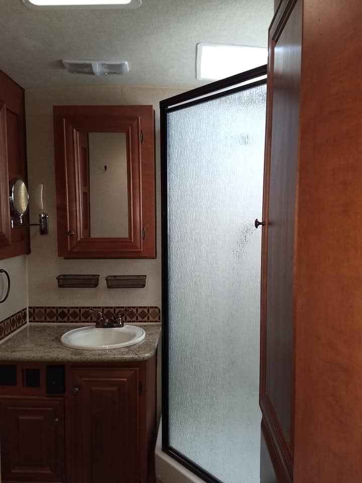 Arctic Fox 28F bathroom with wood vanity and frosted glass shower door