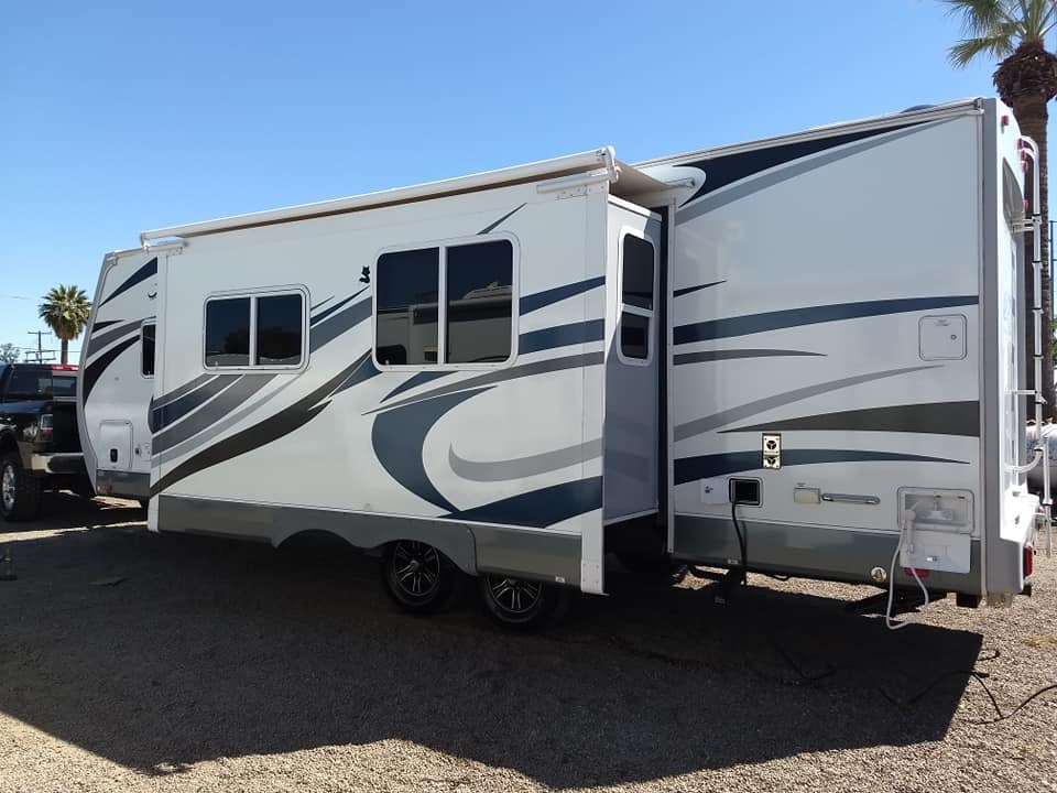 Arctic Fox 28F exterior side view with slide out extended in parking lot