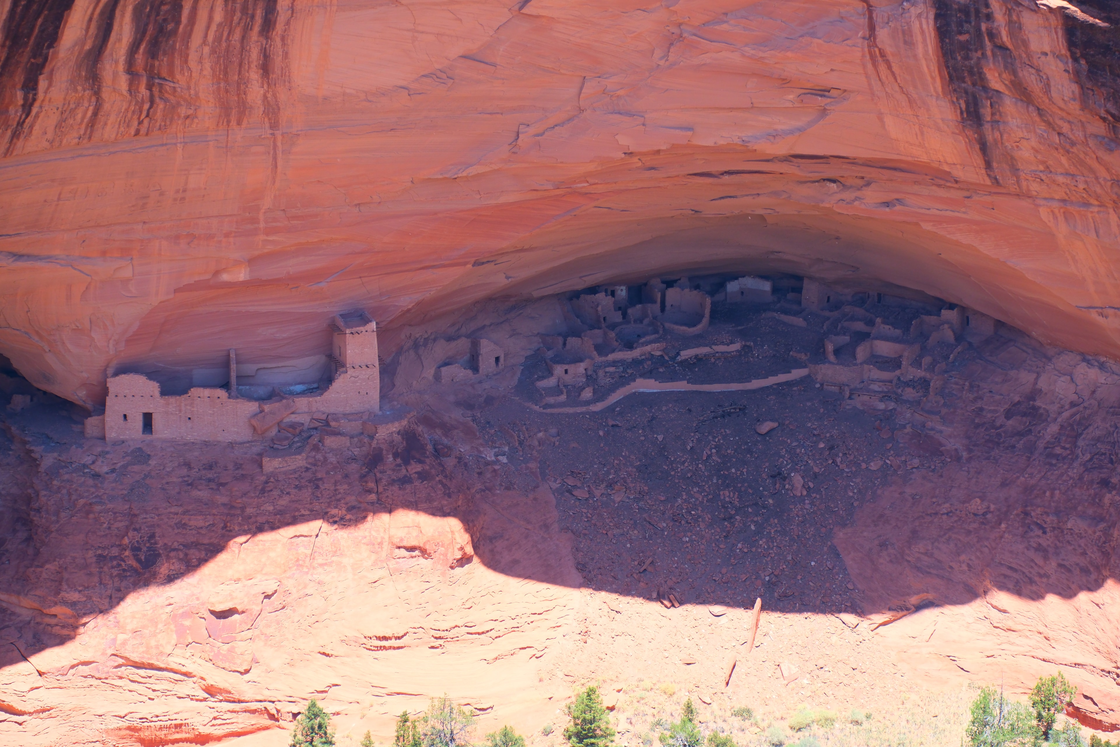White House Ruin at Canyon de Chelly — wide view of the full cliff dwelling complex tucked into a massive orange sandstone alcove