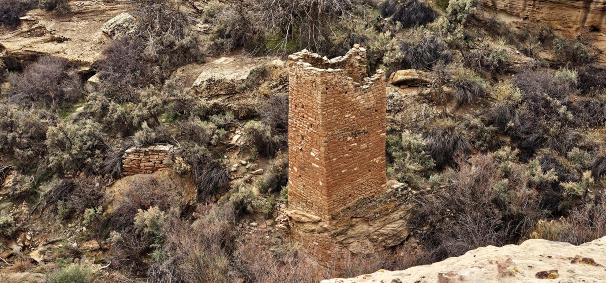Tall square Ancestral Puebloan tower standing alone on the canyon rim at Hovenweep National Monument