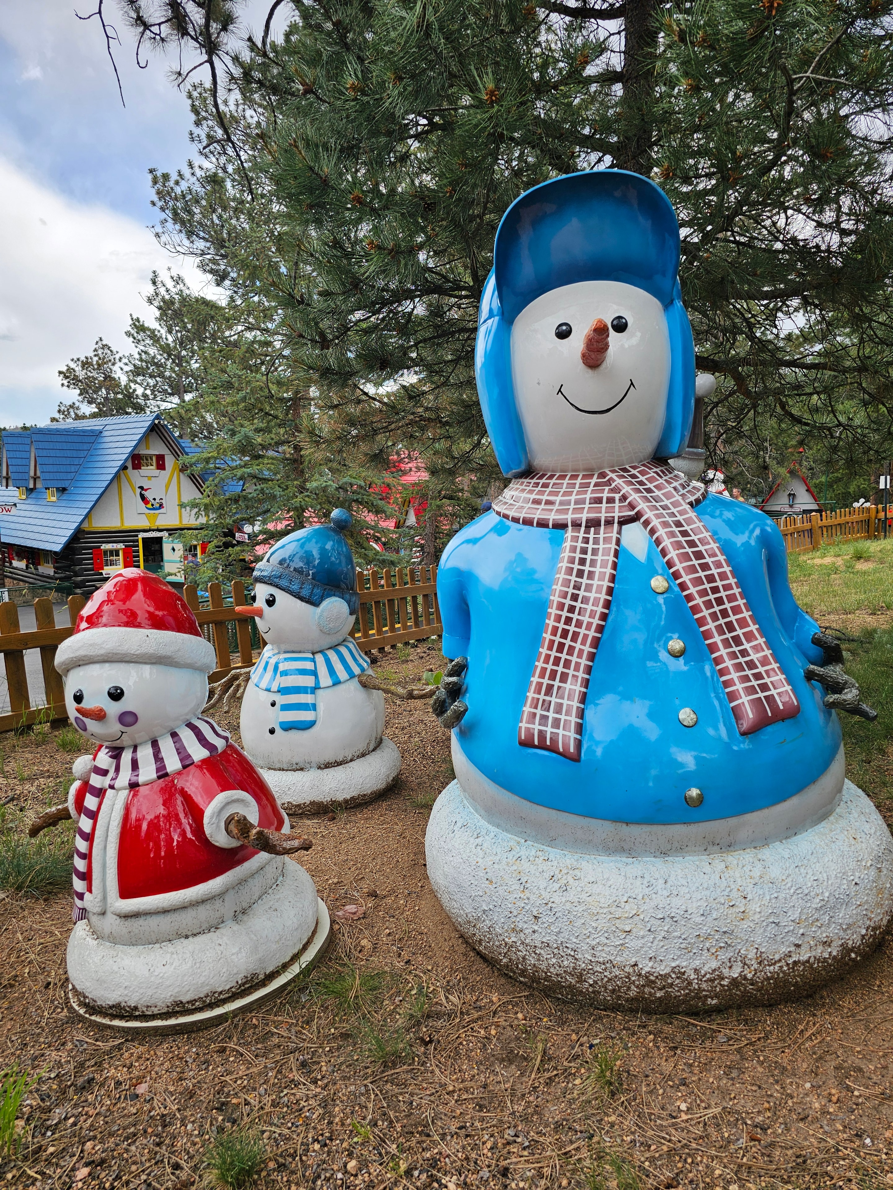 North Pole – Home of Santa's Workshop — snowman family statues, large blue snowman with two smaller ones on park grounds — LOVING LIFE HAVING FUN Brinkley Z3400