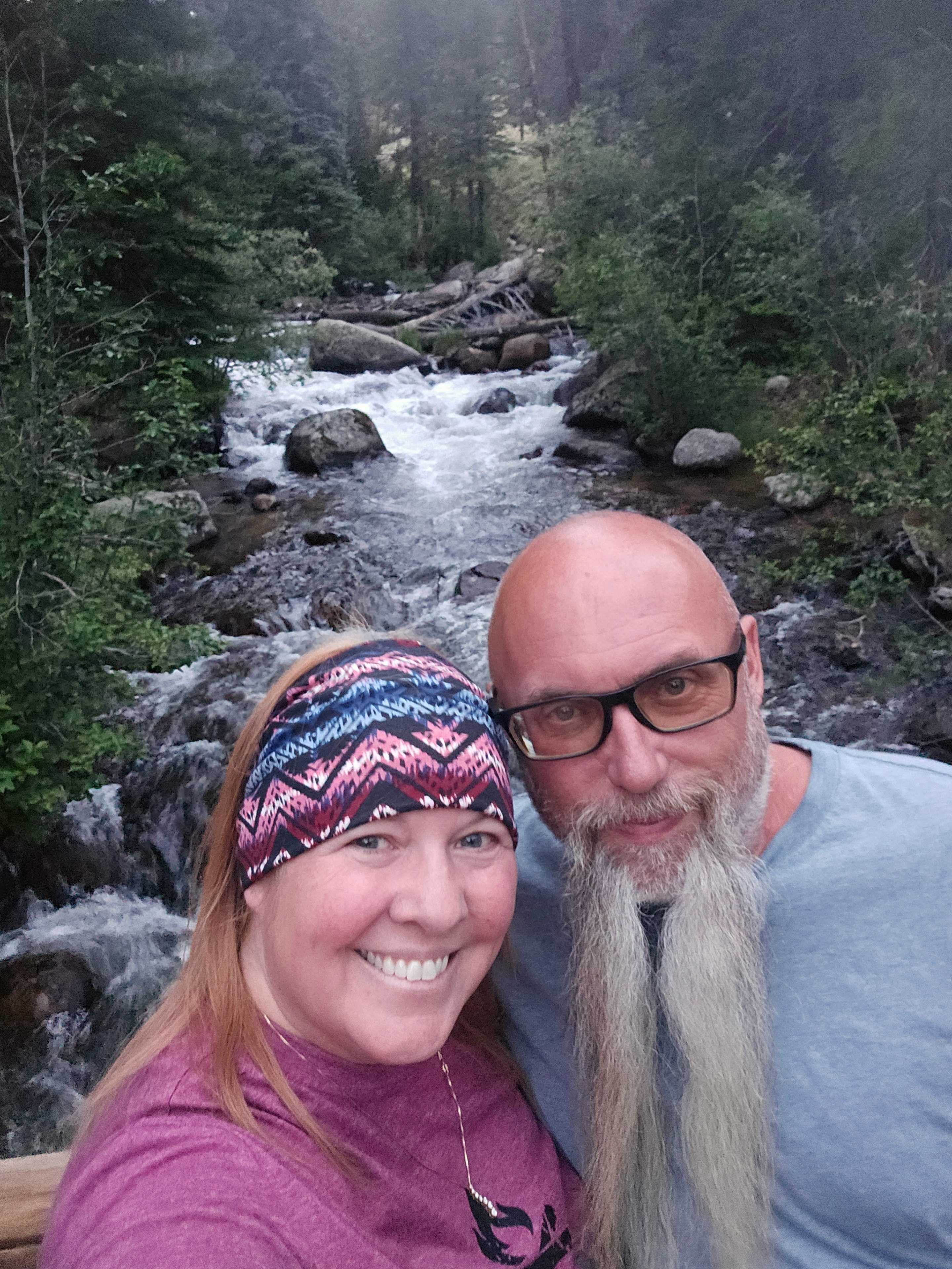 Joe and Tina selfie at Alberta Falls with waterfall and mist behind — Rocky Mountain National Park, Colorado — LOVING LIFE HAVING FUN Brinkley Z3400