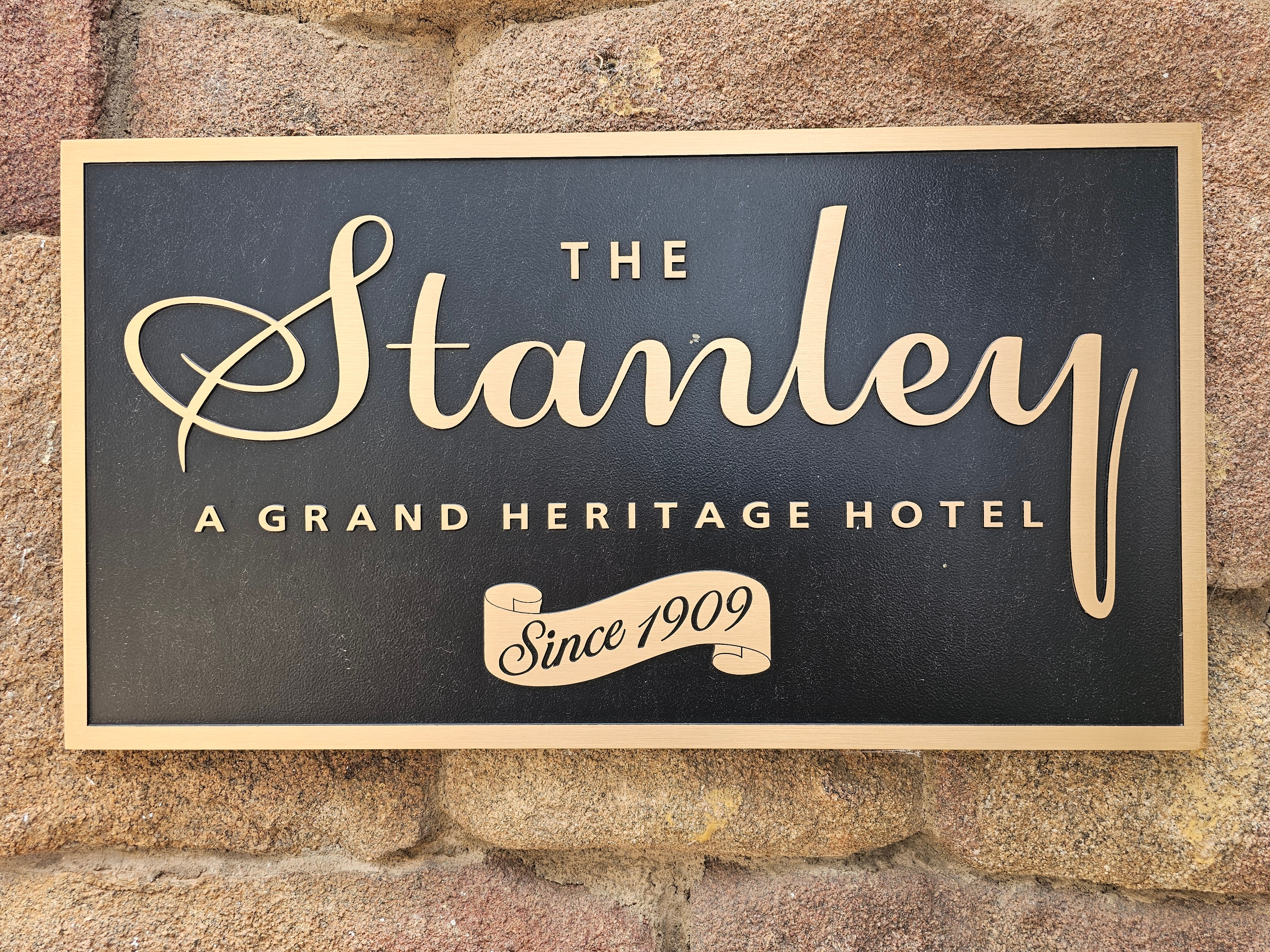 The Stanley Hotel bronze plaque on stone wall — "A Grand Heritage Hotel, Since 1909" — Estes Park, Colorado — LOVING LIFE HAVING FUN Brinkley Z3400