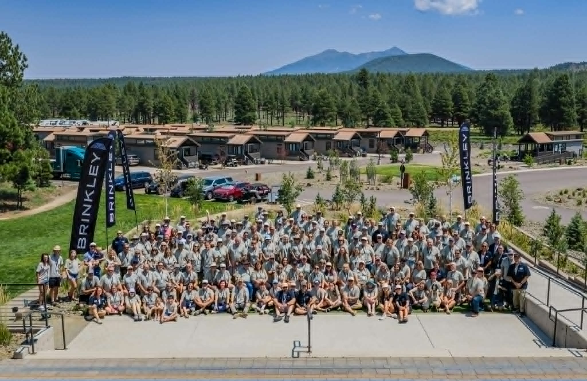 Brinkley Meet-Up #004 group photo at Village Camp Resort Flagstaff with Brinkley banners and San Francisco Peaks