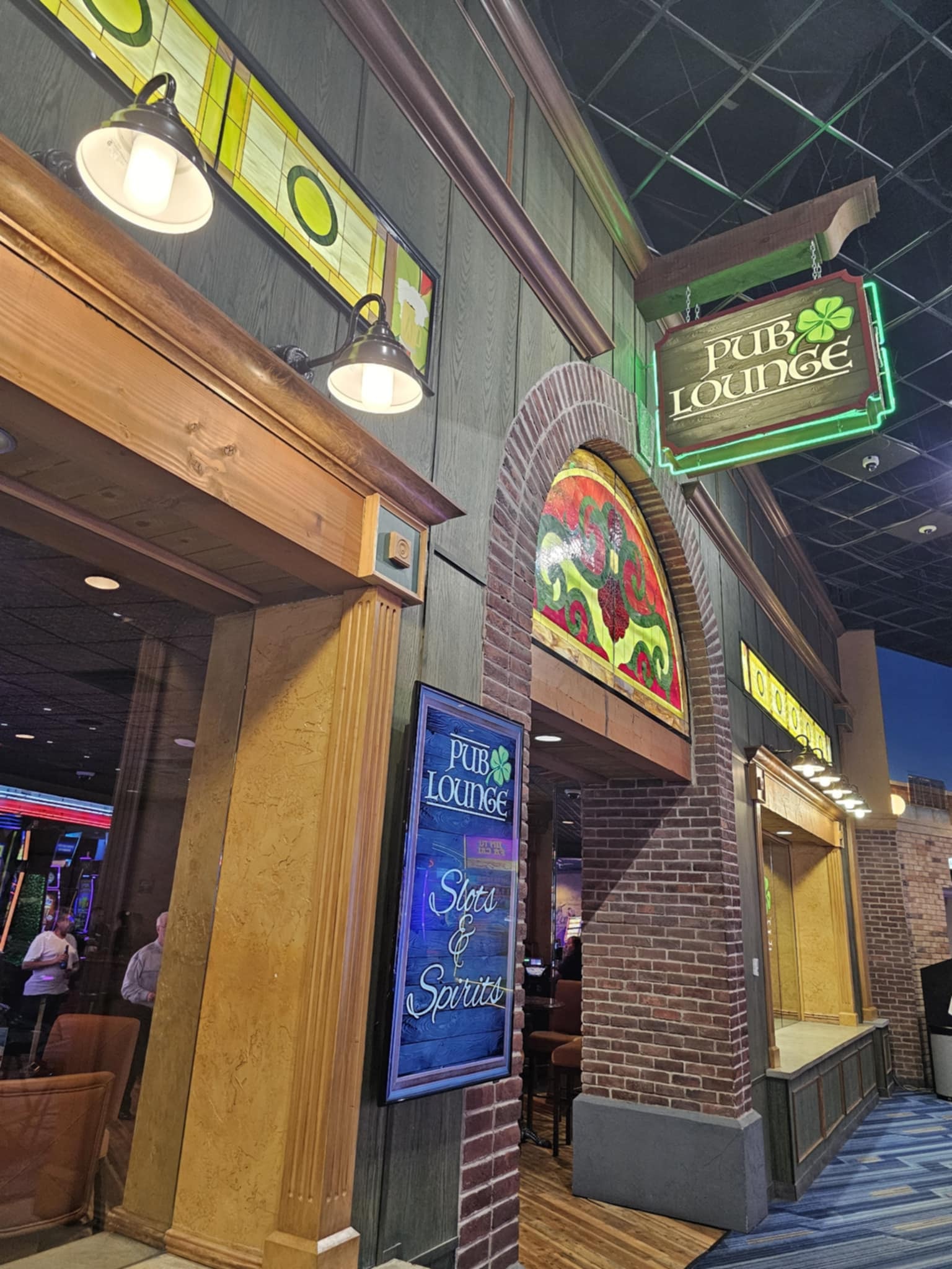 Interior of the Pub Lounge bar at Route 66 Casino Hotel — Jameson rail, tap handles, stained glass panels, and TVs above the bar
