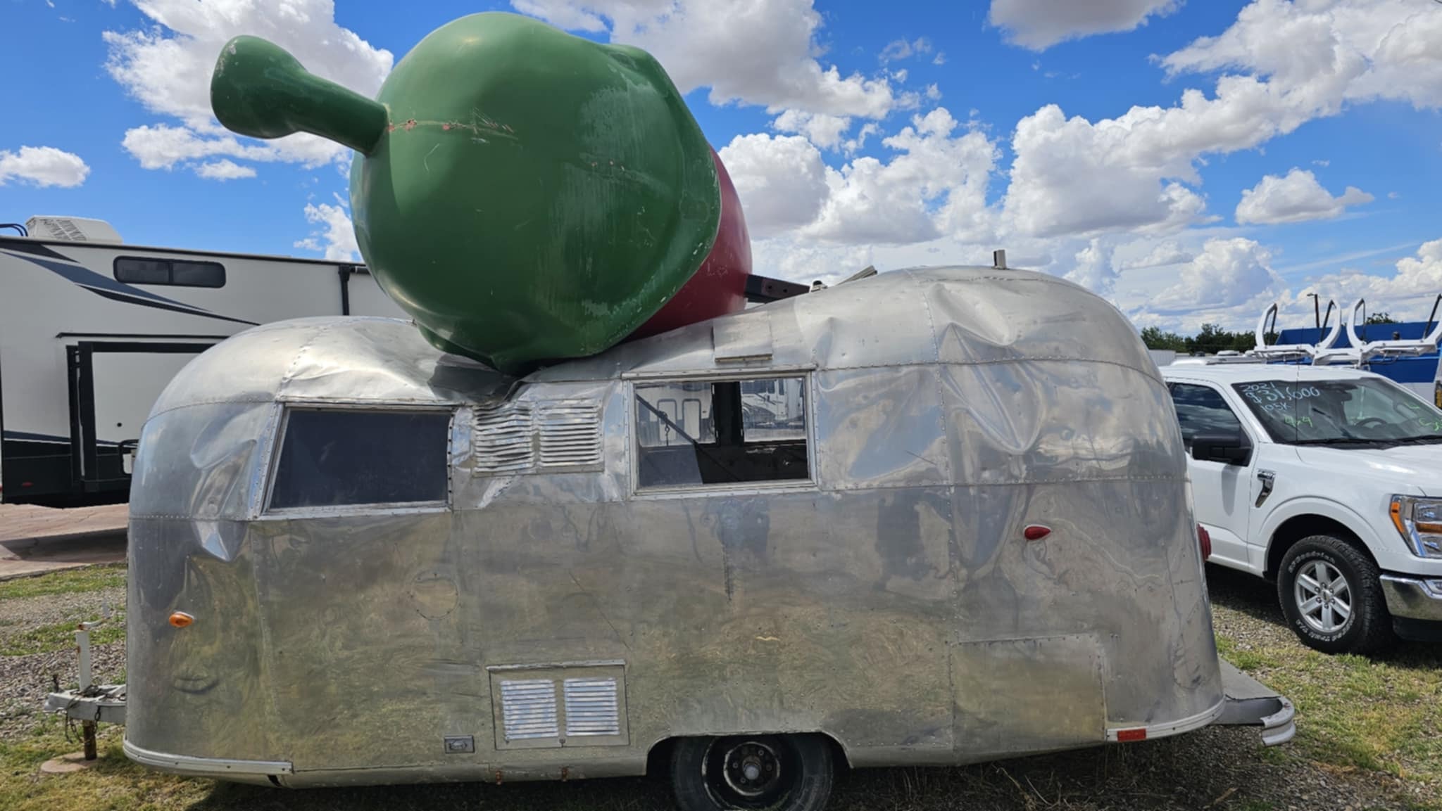 Giant chile pepper sculpture next to a vintage Airstream at the Hatch Chile Festival