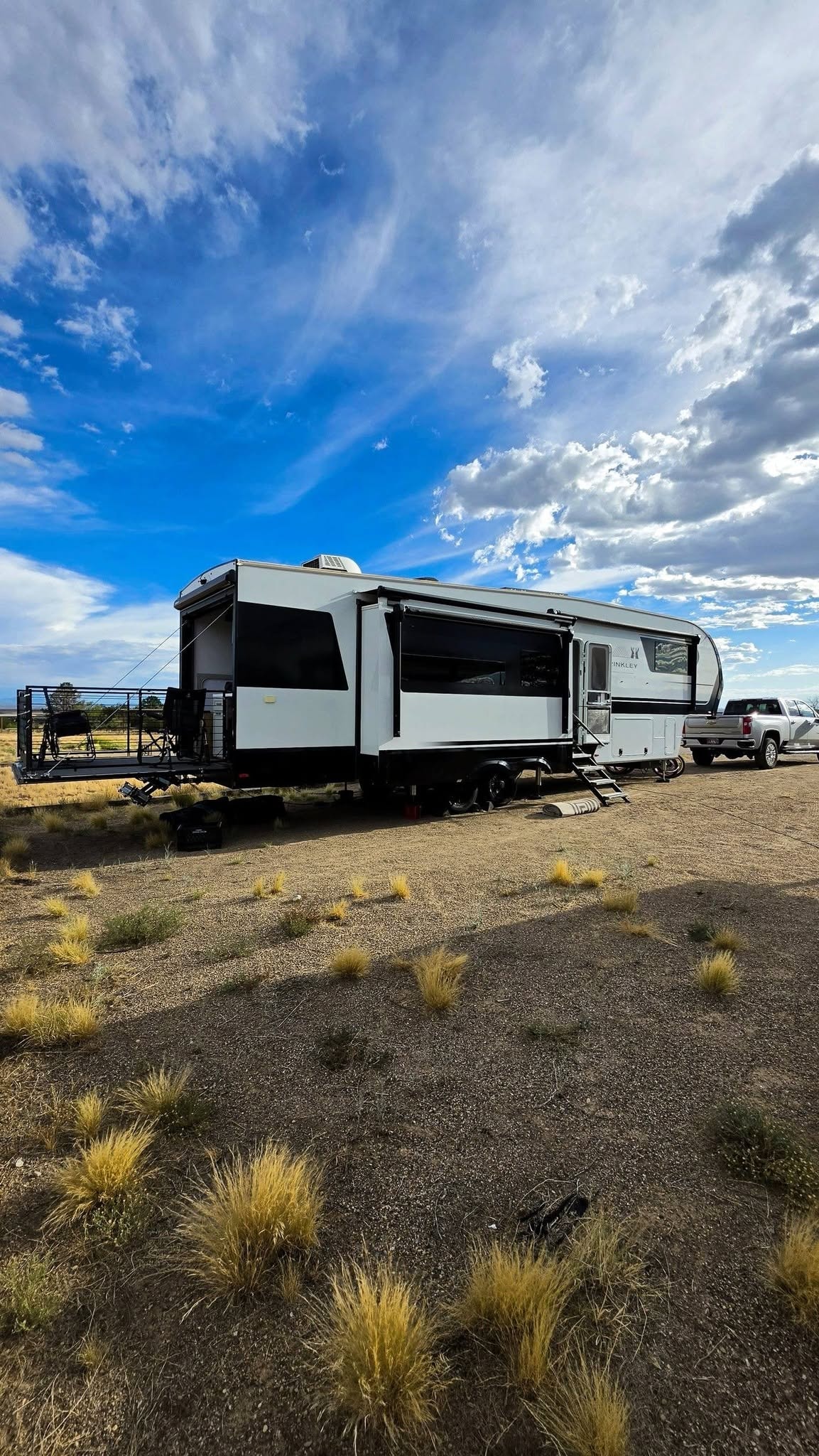 Brinkley Z3400 fifth wheel parked at Cochiti Lake State Park under a dramatic blue sky with billowing white clouds