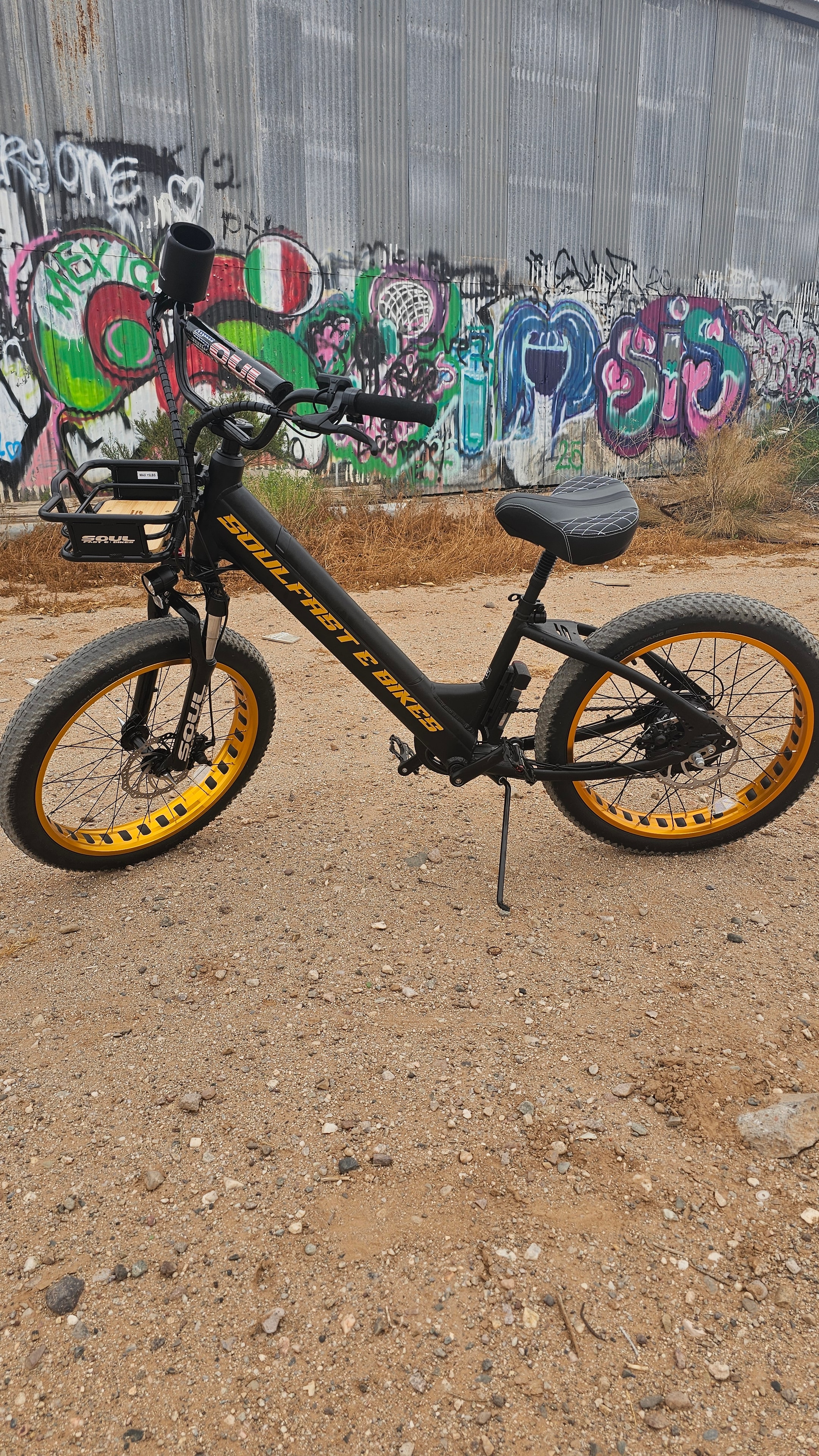 Black and gold Soul Fast e-bike against a colorful graffiti wall