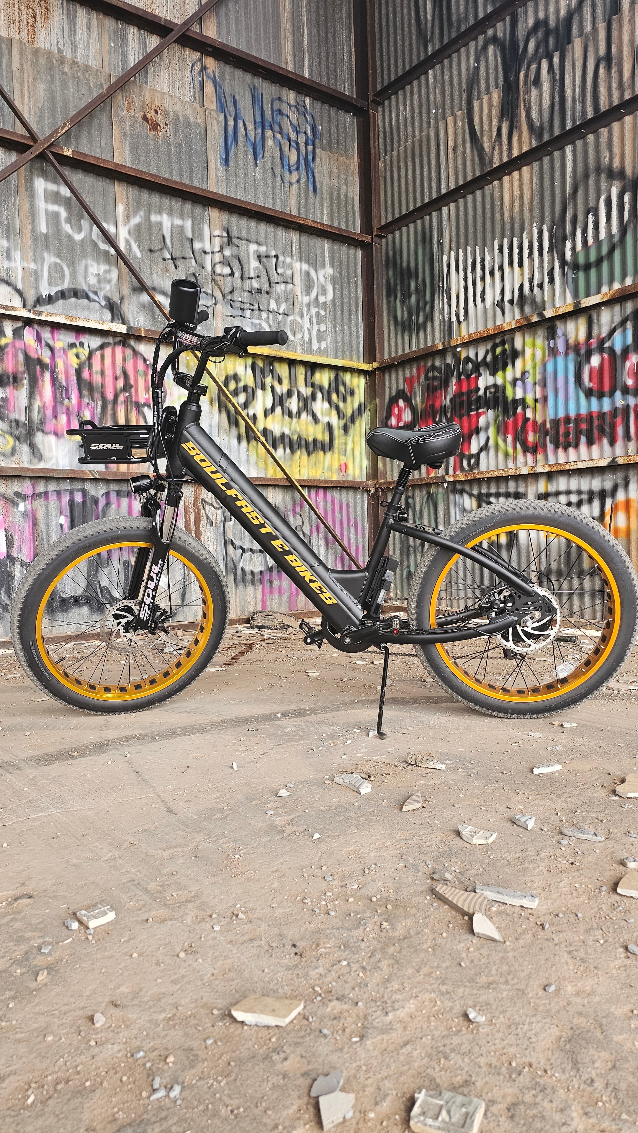 Black and gold Soul Fast e-bike against a graffiti wall — alternate angle