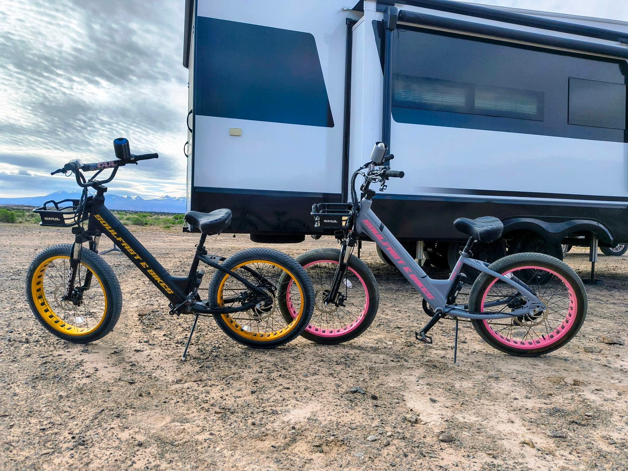 Both Soul Fast e-bikes parked beside the Brinkley in the desert with mountains behind