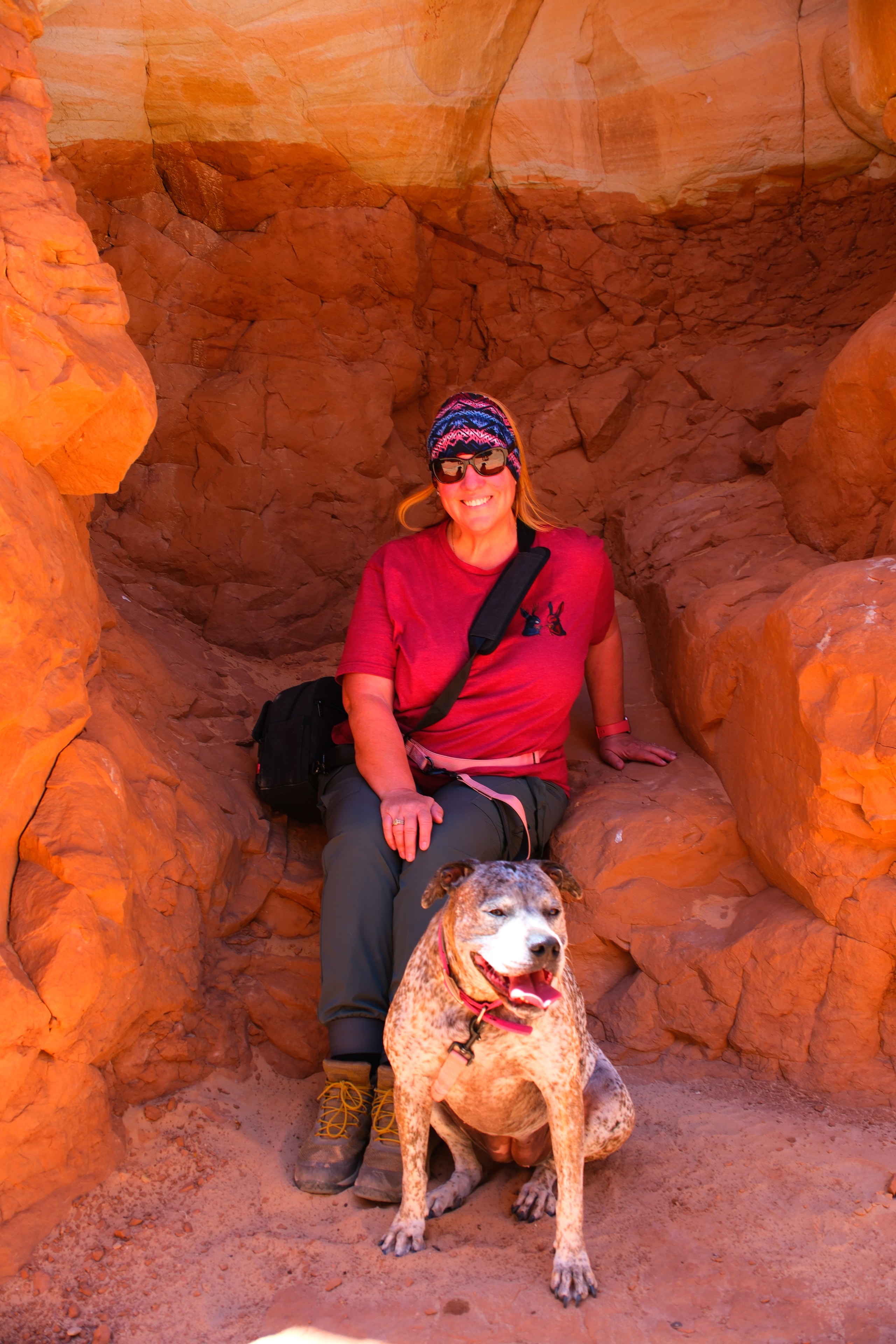 Tina and Reecee inside the Belly of the Dragon tunnel chamber with warm orange walls Utah