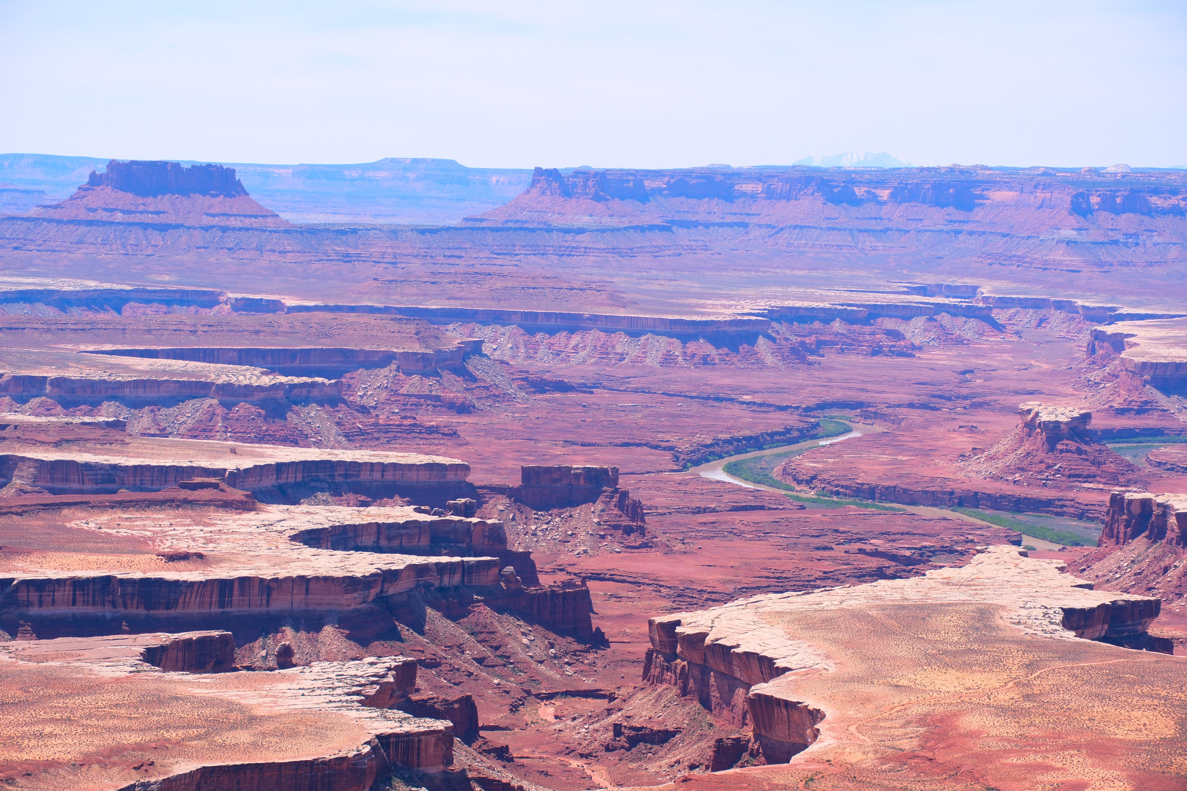 Massive Green River overlook with river snaking through canyon floor layered mesas and distant buttes at Canyonlands National Park Utah