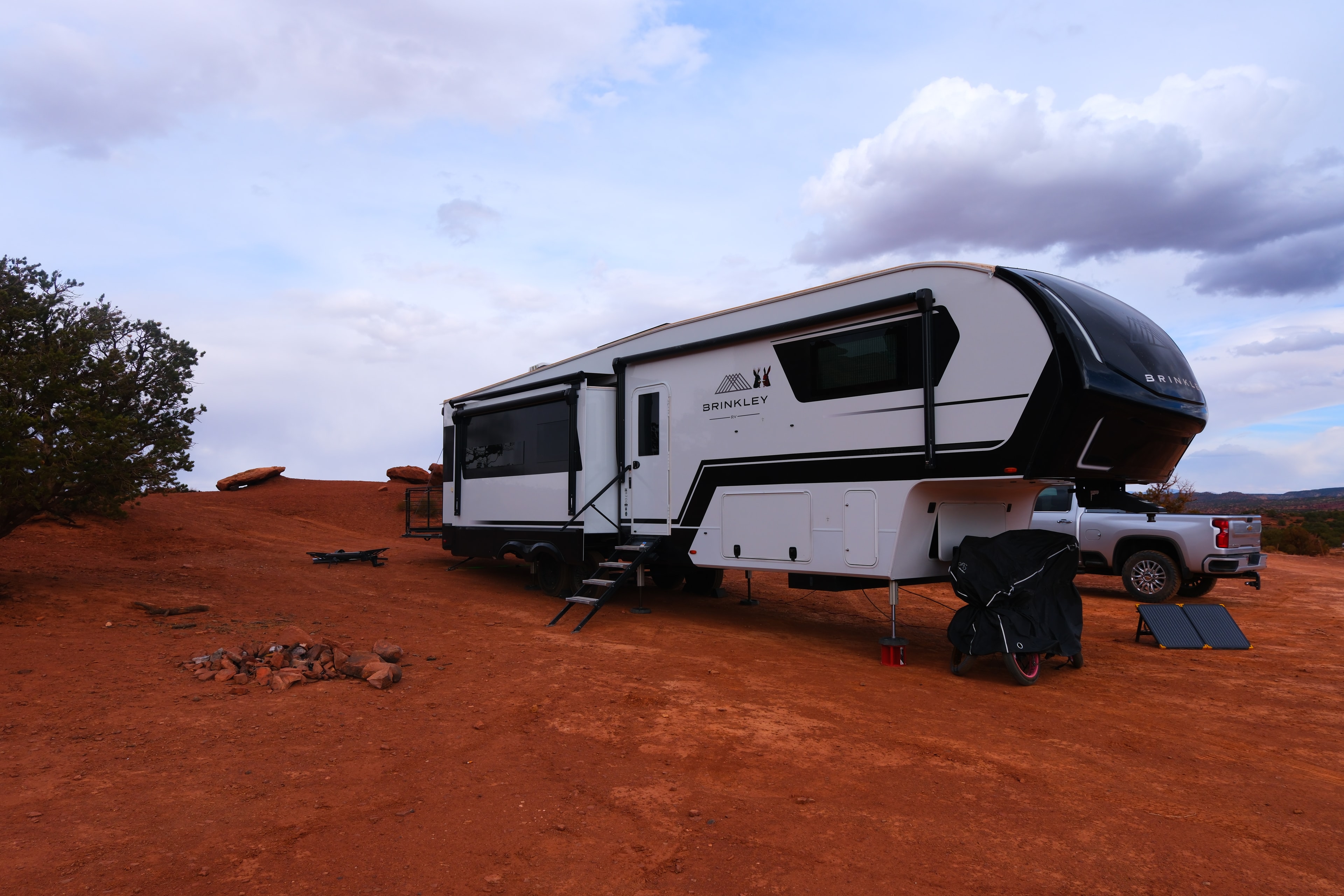 Brinkley Z3400 fifth wheel full side profile with Chevy truck behind fire ring foreground and solar panel at Beas Lewis Road dispersed campsite Capitol Reef Utah