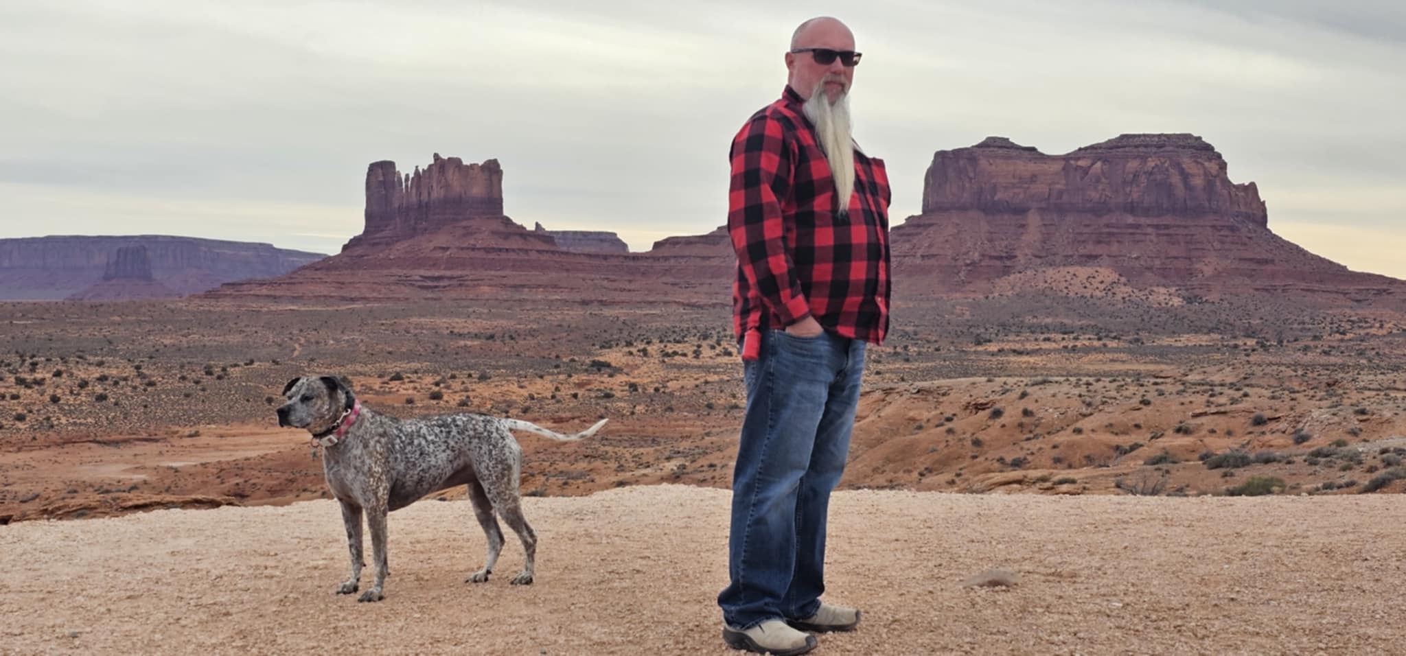 Joe standing with Reecee, the Mittens rising behind them, Monument Valley