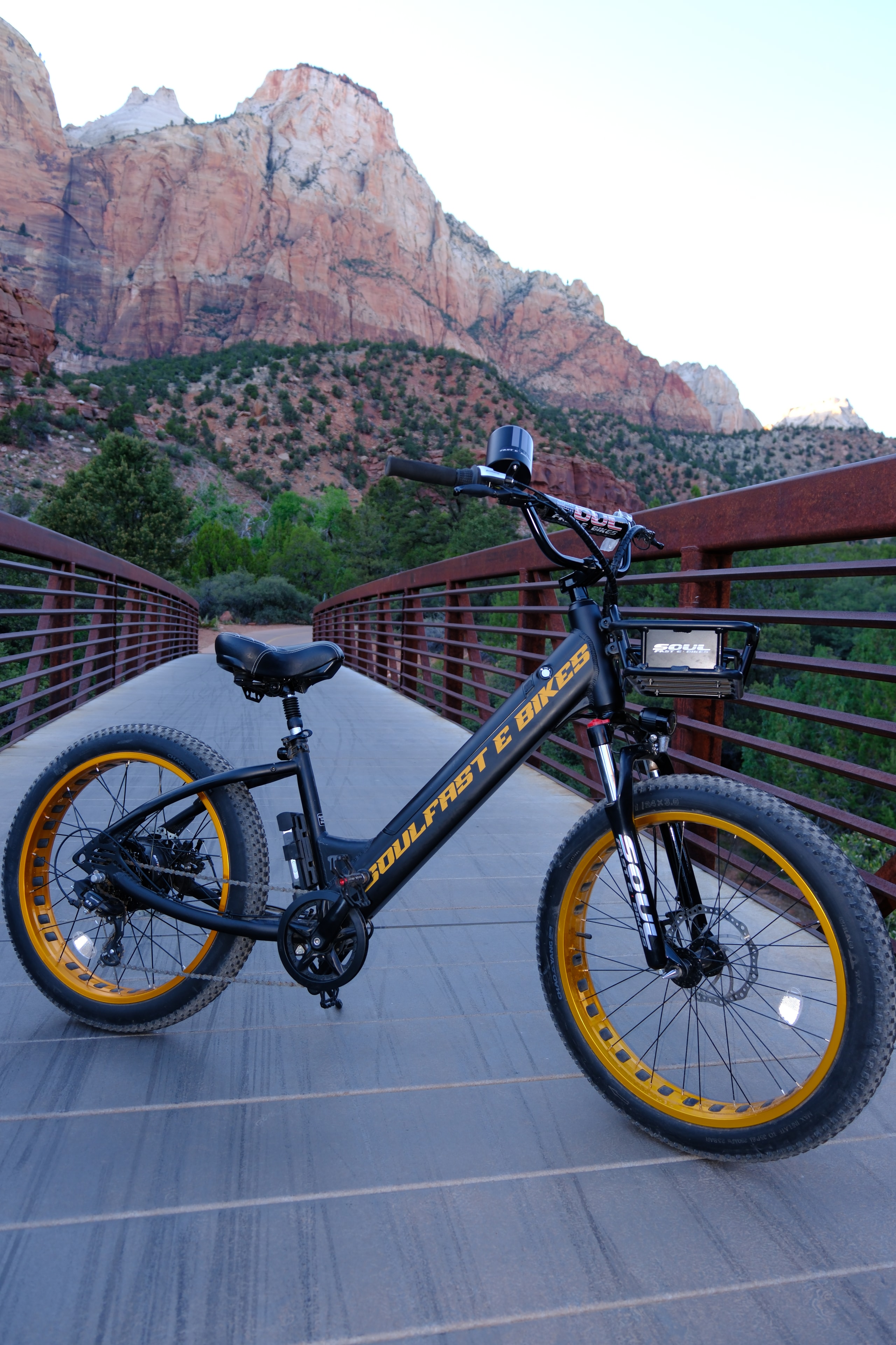 Black and gold Soul Fast e-bike on a bridge with canyon below — overhead shot