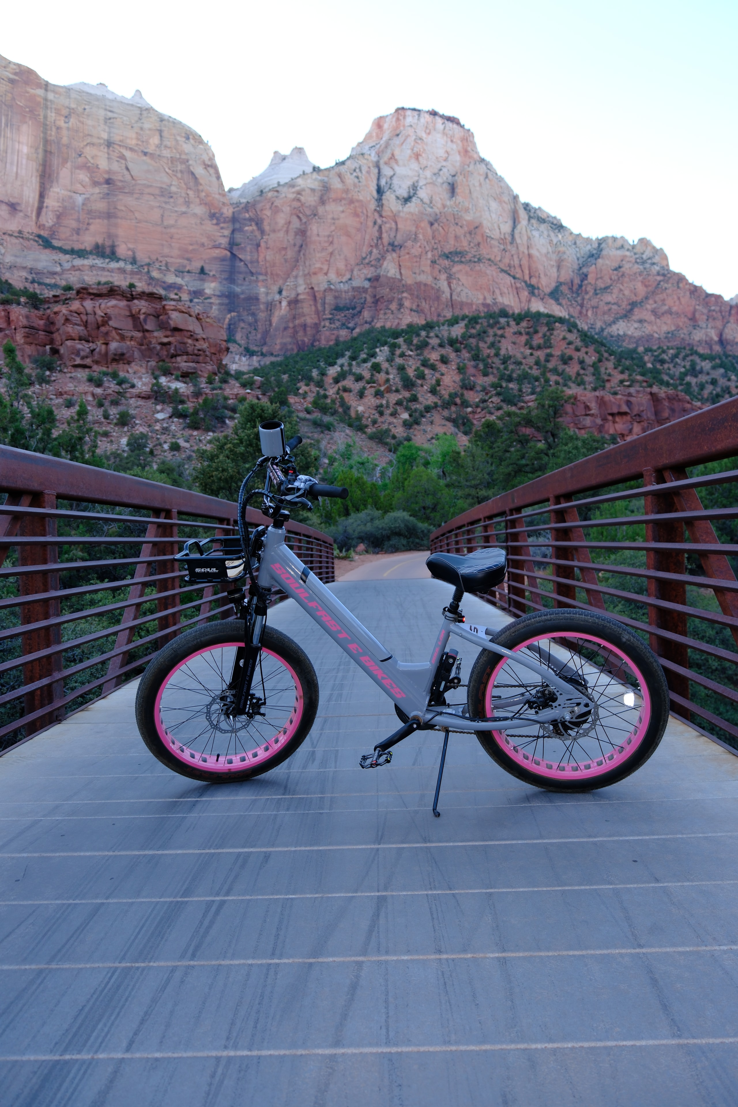 Pink Soul Fast e-bike on a bridge with canyon below — overhead shot