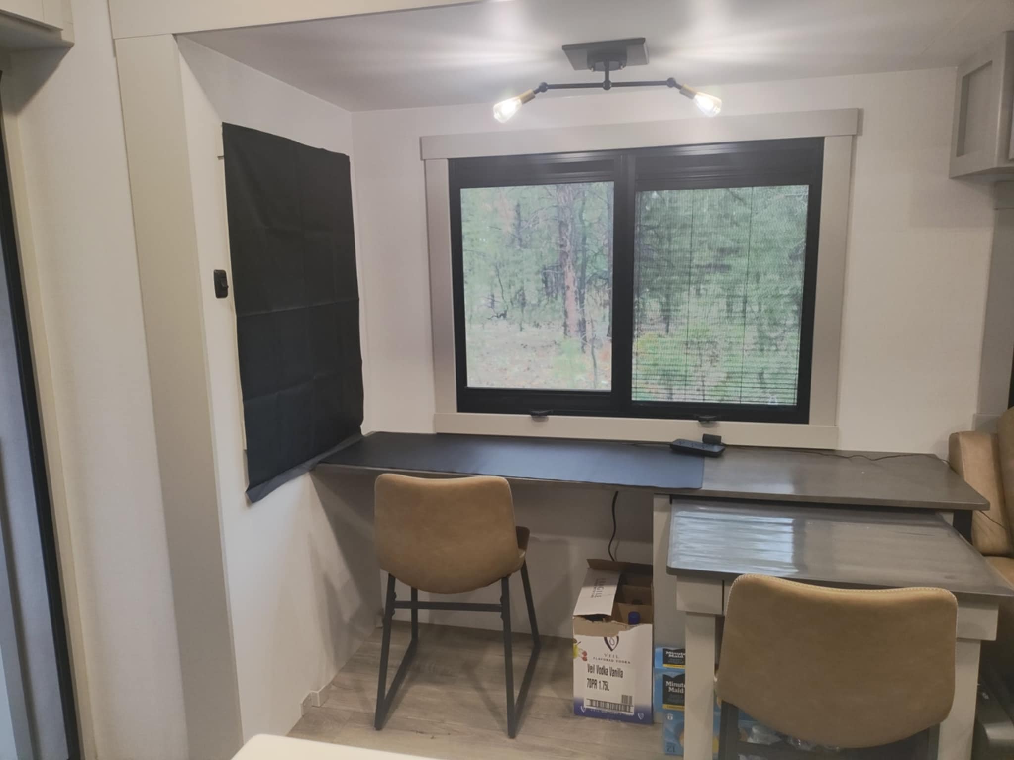 Joe's Dinesk desk area in the Brinkley Z3400 — empty and ready for the workday, forest view through the window