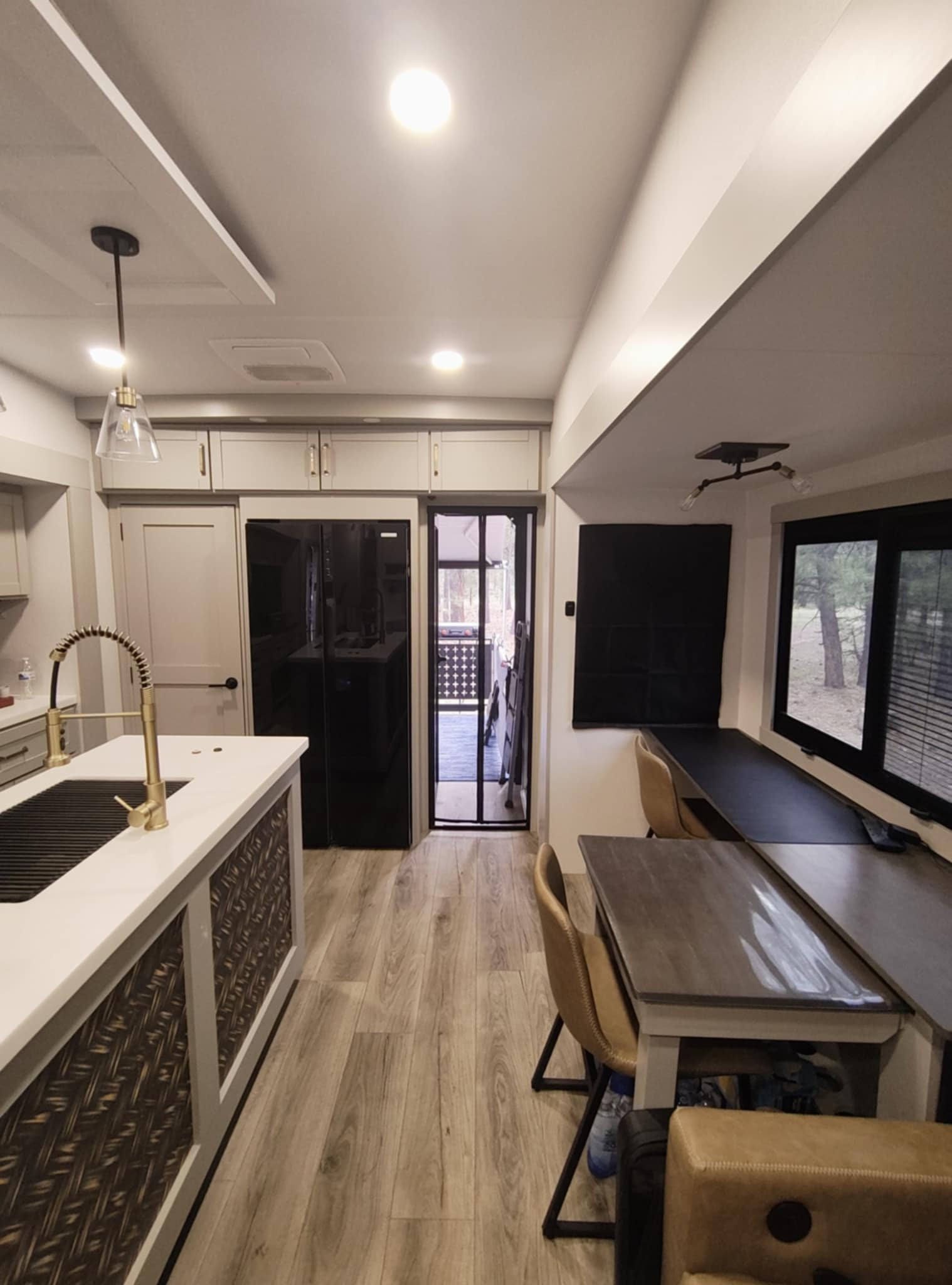 Brinkley Z3400 interior showing the Dinesk workstation, kitchen island, and patio door to the forest