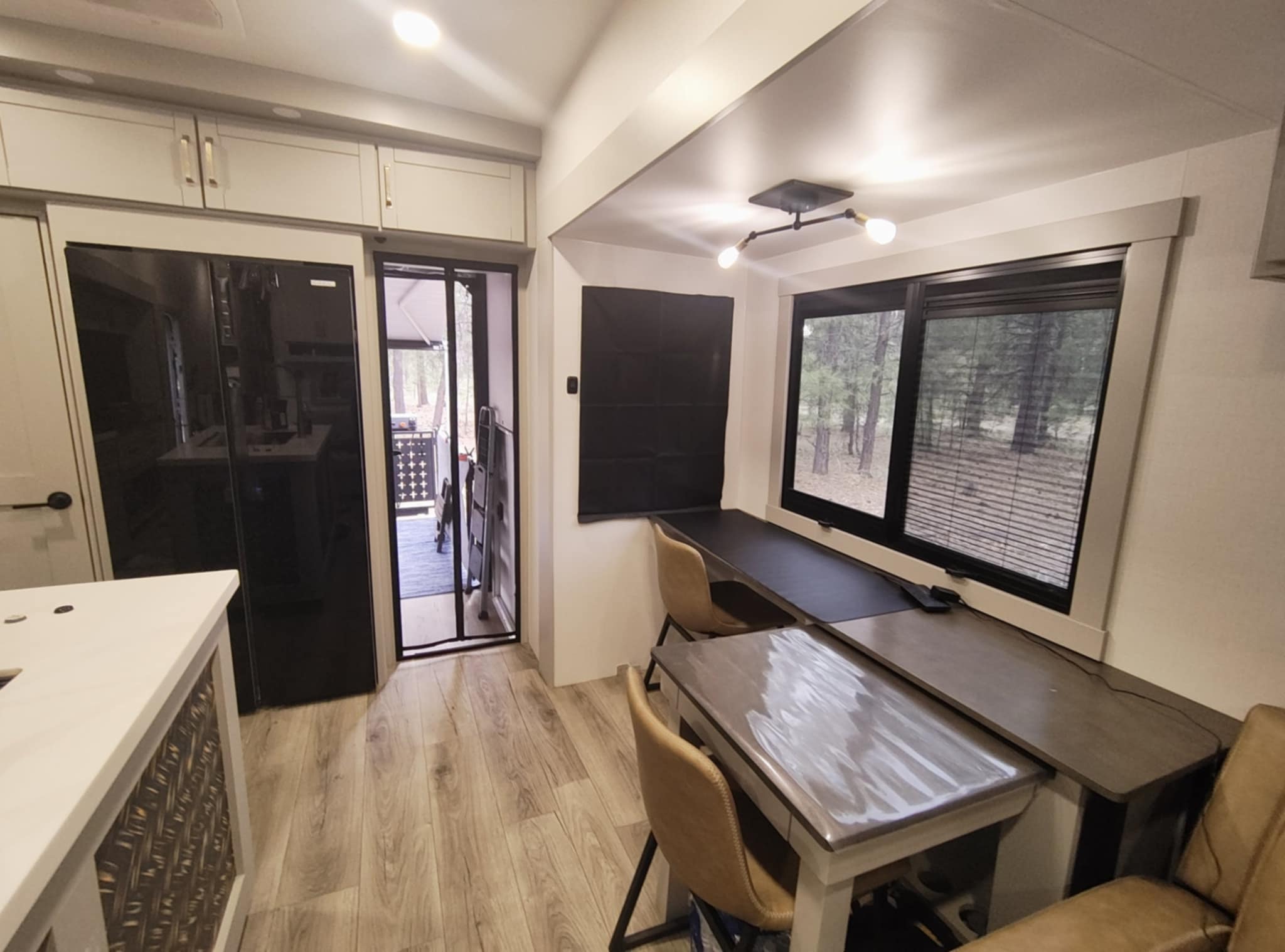 Joe's office in the Brinkley Z3400 — the Dinesk workstation with dual monitors, patio door, and forest views